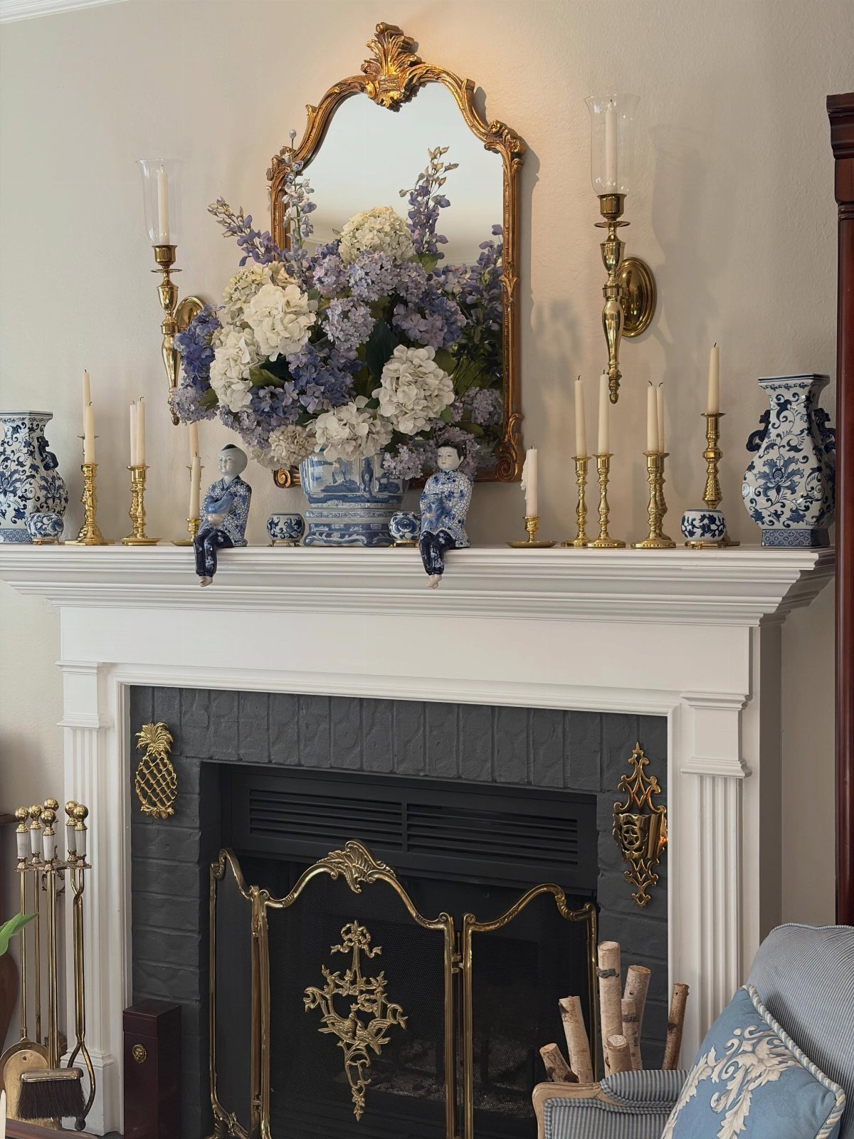 12 Blue White Living Room Ideas with Photos and Styling Tips 3 White fireplace mantel with blue and white porcelain and a gold-framed mirror above.