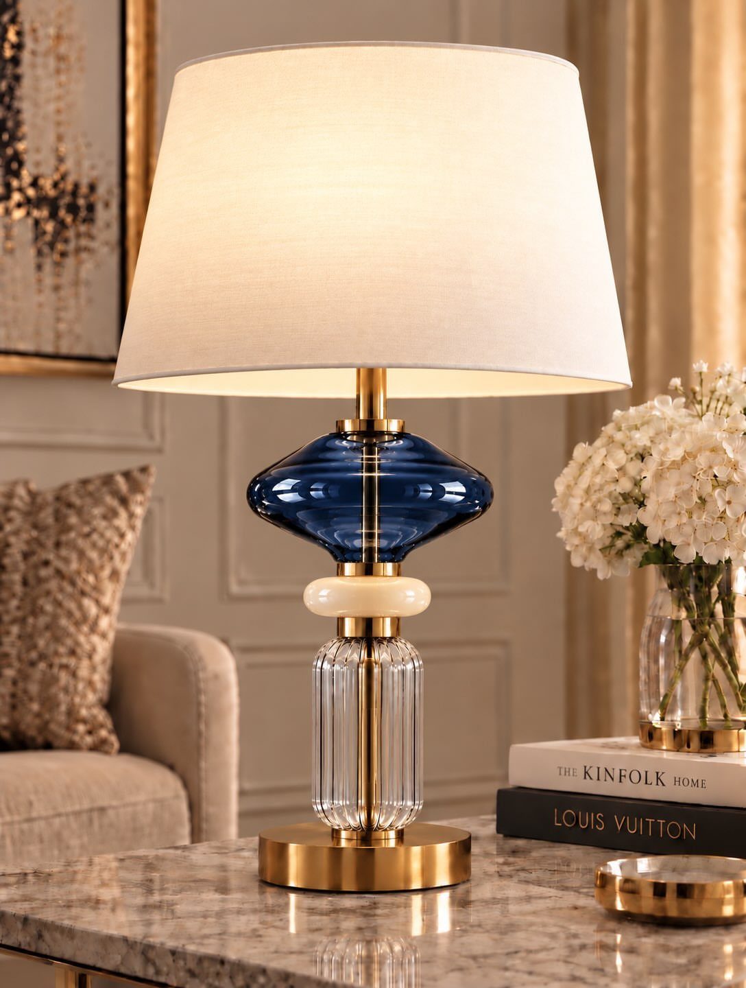 Table lamp with gold accents and blue glass on a marble surface