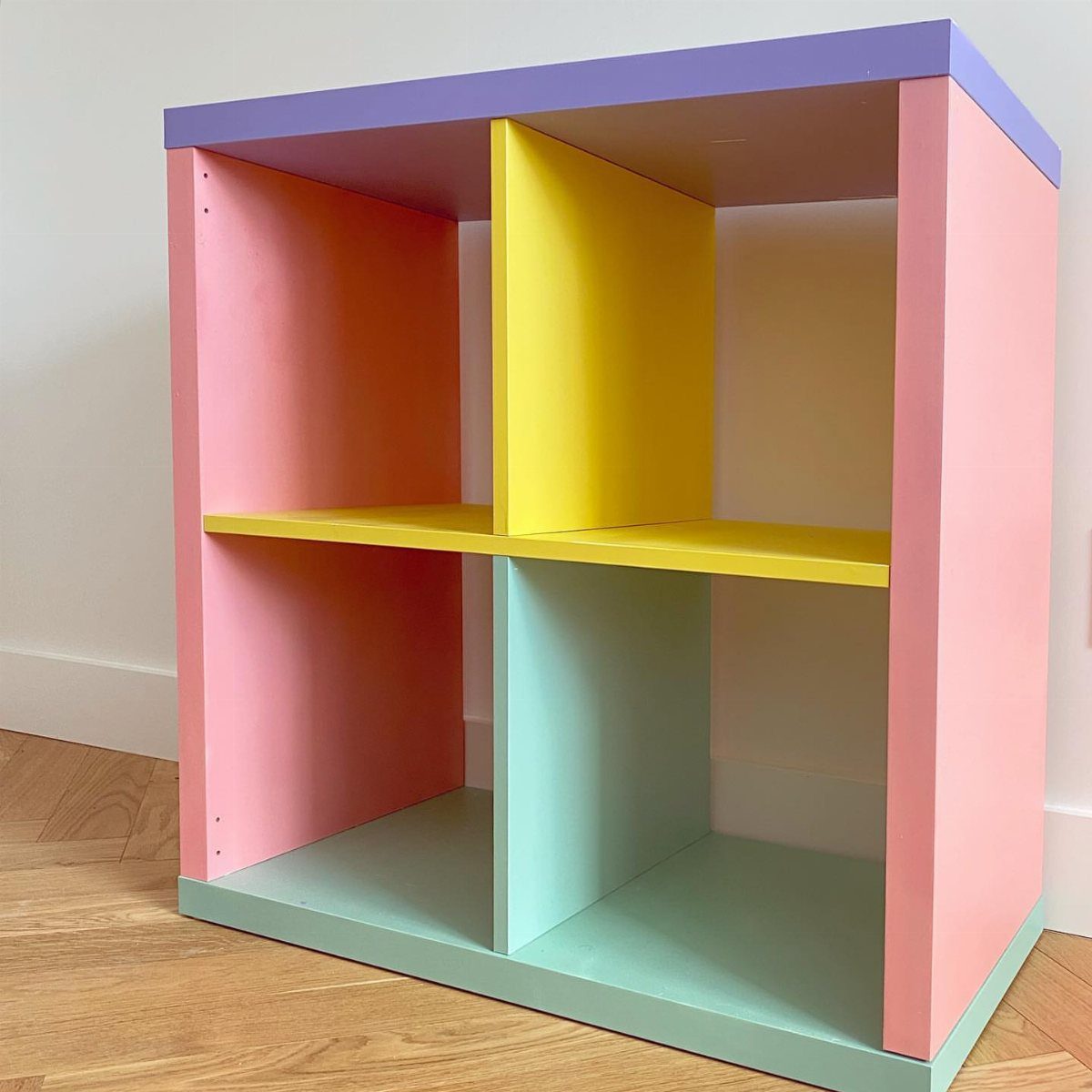 13 Cube Organizer Ideas for Your Living Room Layout 9 Colorful wooden cube organizer with pink, purple, yellow, and green painted sections.