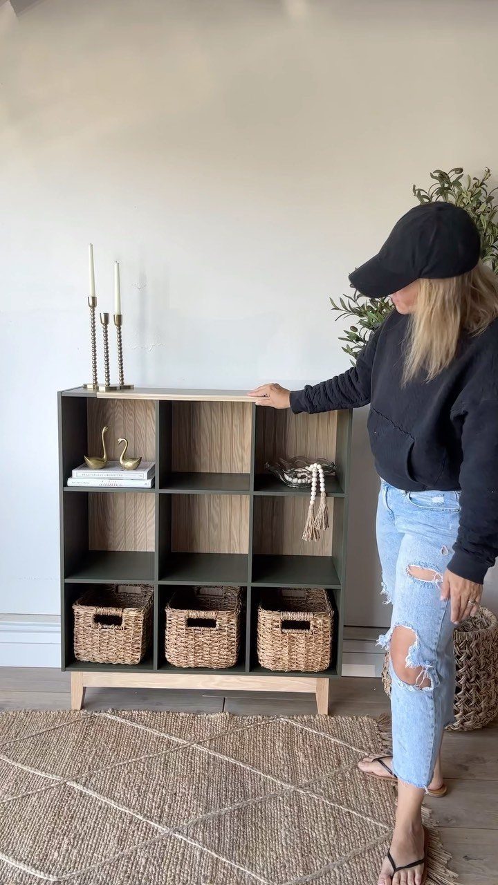 13 Cube Organizer Ideas for Your Living Room Layout 4 Dark green cube organizer with a light wood plank topper and tapered legs.