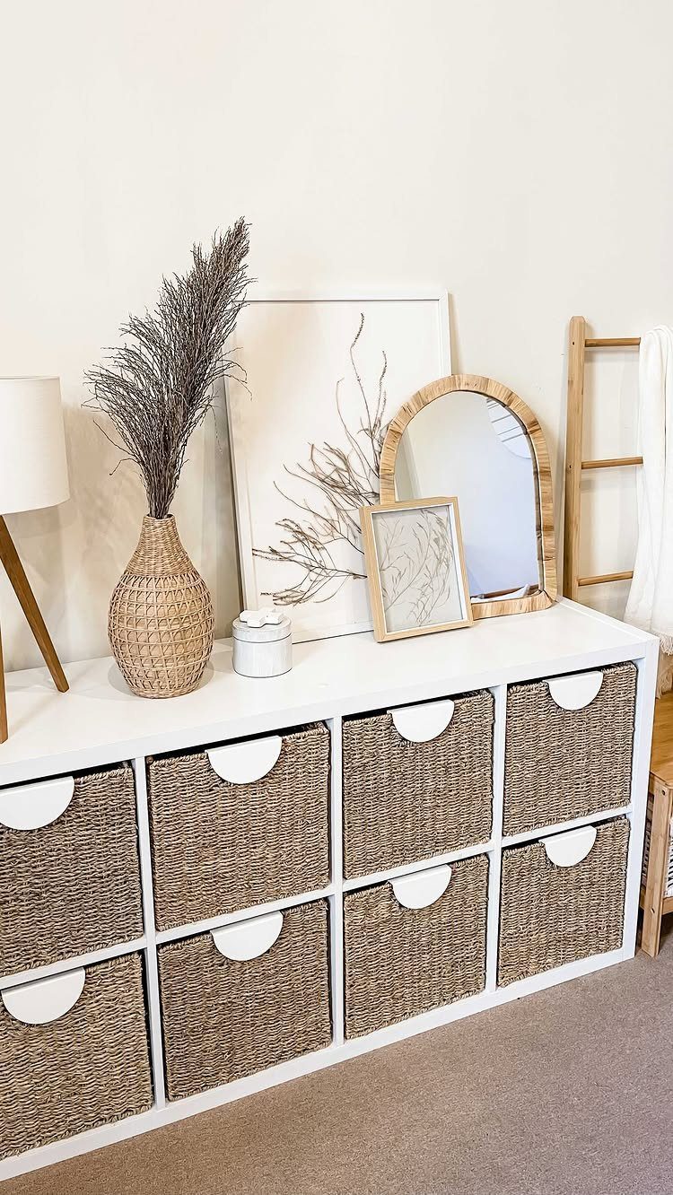 13 Cube Organizer Ideas for Your Living Room Layout 7 White cube organizer with wicker baskets topped with home decor in a living room.